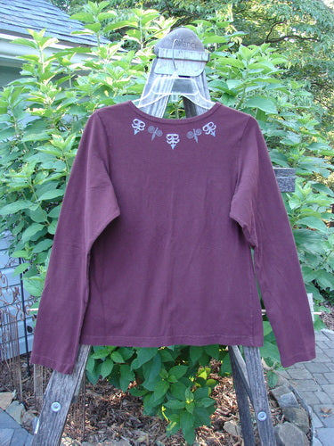 1999 Cotton Lycra Long Sleeved Layering Top Necklace Red Wine Size 0 displayed on a wooden rack, showcasing its medium-weight fabric and full-length sleeves, perfect for layering.