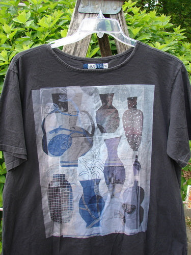 Barclay Fiona Straight Tee Modern Vase Storm Size 0, featuring a grid of stylized vases in gray, blue, and mauve tones, displayed outdoors on a hanger, showcasing its rounded neckline and wide sleeves.