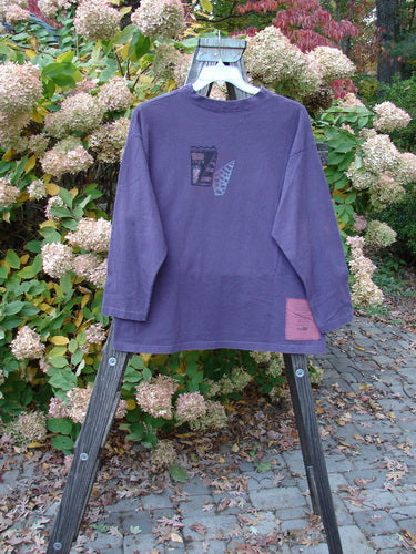 1997 Long Sleeved Tee Spirit Drum Ionic Size 1: A long sleeved shirt on a rack, featuring a thicker cotton, wider ribbed neckline, and drop shoulders for a cozy fit. The intriguing Spirit Woman and Drum theme paint adds an artistic touch. Bust 50, Waist 50, Hips 50, Length 28.