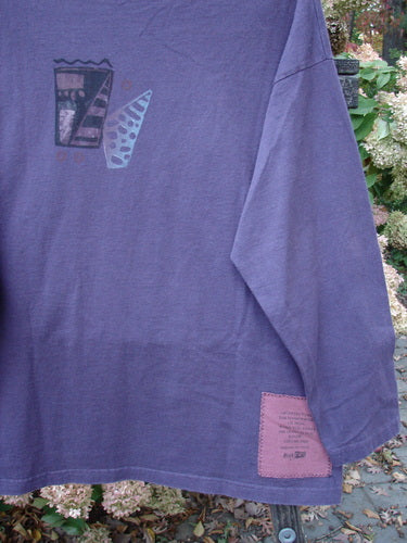 1997 Long Sleeved Tee Spirit Drum Ionic Size 1: A purple shirt with a patch on it featuring a label and a close-up of the intriguing Spirit Woman and Drum theme paint.