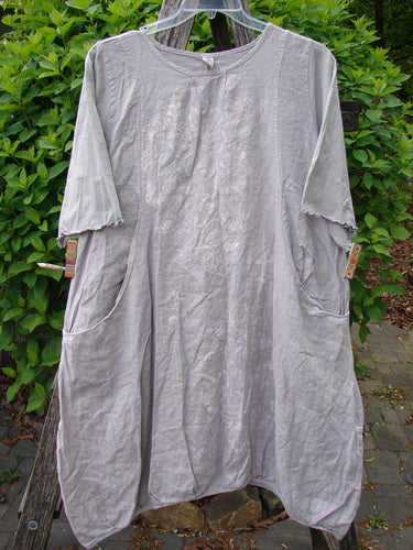 Barclay Cotton Sleeved Frenchtown Studio Dress Wild Flower Rice Paper Size 0, featuring a loose fit, round neckline, elbow-length sleeves, and angular pockets, displayed against a leafy backdrop.