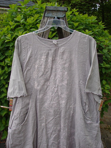 Barclay Cotton Sleeved Frenchtown Studio Dress Wild Flower Rice Paper Size 0, showcasing a loose fit with elbow-length sleeves, embroidered bodice, round neckline, and front pockets against a green shrub backdrop.