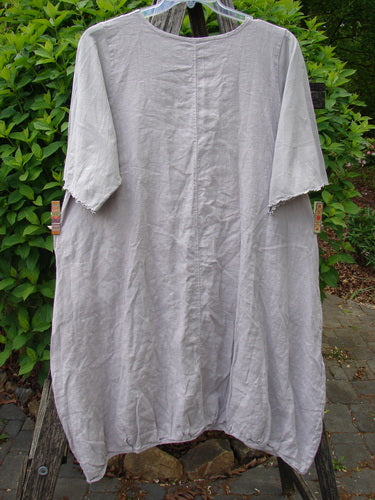 Barclay Cotton Sleeved Frenchtown Studio Dress Wild Flower Rice Paper Size 0, featuring elbow-length sleeves, a rounded neckline, ballooned hem, and angular pockets, hanging outdoors on a clear hanger.