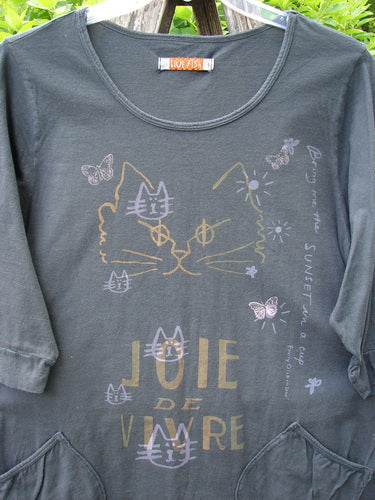 Barclay Banded Artist Pocket Top Metallic Kitty Kitty Black Size 1 features pastel cat and butterfly prints, three-quarter sleeves, and two front pockets, embodying creative freedom with its A-line shape and banded details.