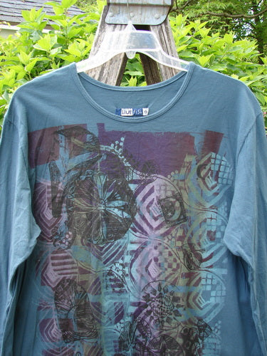 Barclay Long Sleeved Studio Tee Flower Garden Block Tealen Size 0, featuring an abstract geometric and floral design, displayed outdoors on a hanger, highlighting its boxy shape and long sleeves.