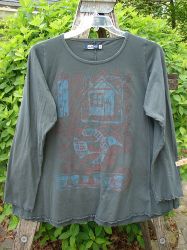 Barclay Long Sleeved Cafe Tee Love Dove Home Grey Hunter Size 0, featuring a stamped-style graphic with a house, bird, and flowerpots, hanging on a hanger outdoors, showcasing sweet curly edgings.