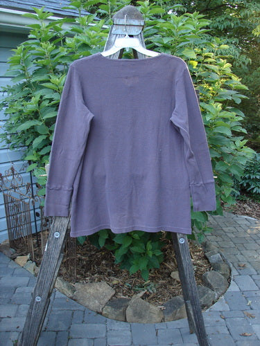 2000 Thermal Lu Top Unpainted Eggplant Size 1 displayed on a wooden rack, featuring ribbed cuffs, rubberized buttons, and a slight A-line shape, showcasing its lightweight, ribbed texture.