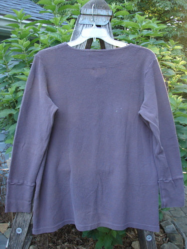 2000 Thermal Lu Top Unpainted Eggplant Size 1 on a clothes rack, featuring ribbed texture, long sleeves with ribbed cuffs, and rubberized buttons, showcasing its slight A-line shape and lightweight drape.