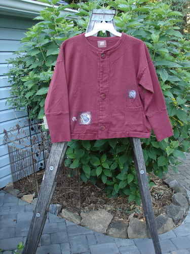 1999 Cottage Cardigan Heart Cup Cinnamon Size 0 displayed on a wooden stand, showcasing its boxy shape, ribbed lower sleeves, double-layered front pocket, and oversized vintage buttons.