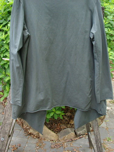 Barclay Cotton Lycra Gather Collar Open Front Jacket in Unpainted Forest Size 1 displayed on a wooden frame, showcasing its elegant drape, unique neckline, and dual inseam side pockets amidst outdoor foliage.