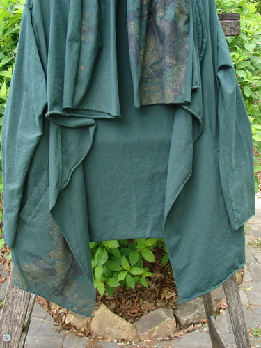 Barclay Cotton Lycra Gather Collar Open Front Jacket Golden Forest Size 0 drapes elegantly over a wooden support, showcasing its unique one-sided drawcord neckline and flowing design amidst greenery.