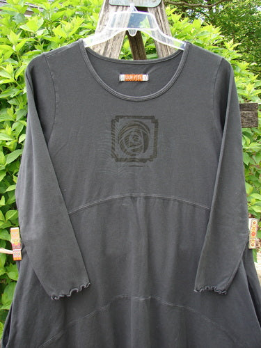 Barclay Cotton Lycra Shape Dress Feather Rose Raven Size 1 hanging outdoors, featuring three-quarter lettuce-edge sleeves, scoop neckline, centered feather rose design, and an empire waist seam.