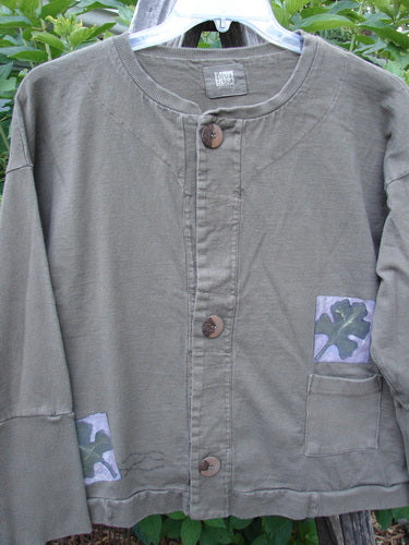 1999 Cottage Cardigan Forest Leaf Mud Size 0 featuring ribbed lower sleeves, double-layered neckline, and three oversized vintage buttons, adorned with a Blue Fish patch and forest leaf theme paint.