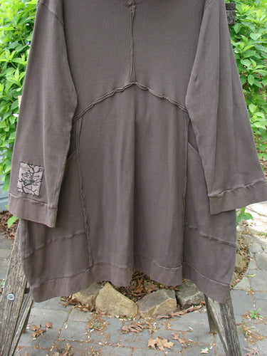 Barclay Patched Thermal Cowl Neck Reverse Stitch Pocket Pullover Bark Size 0, featuring a cozy turtleneck, exposed seams, and a unique sleeve patch, hangs outdoors with a flared A-line design.