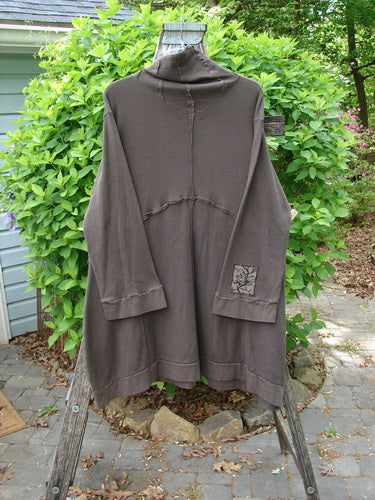 Barclay Patched Thermal Cowl Neck Reverse Stitch Pocket Pullover Bark Size 0 displayed on a wooden ladder, highlighting its cowl neck, reverse stitch details, and unique panel design, outdoors.