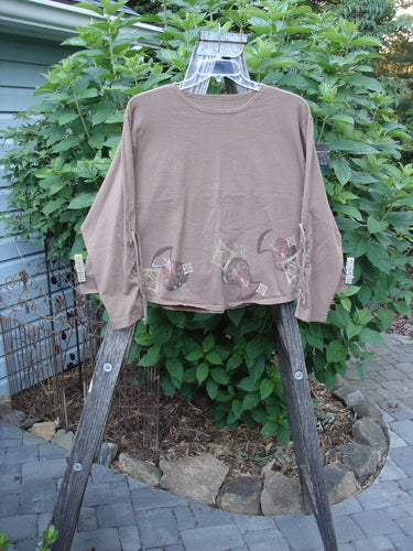 1997 Chandra Top Holiday Diamond Mandorla Size 1 on a wooden ladder, showcasing full lower sleeve lacings, rounded wide hemline, and drawcord back, from Bluefishfinder.com's vintage collection.