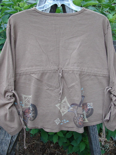 1997 Chandra Top Holiday Diamond Mandorla Size 1 on a wooden rack featuring full lower sleeve lacings, a wide hemline, a rolled neckline, and a blue fish patch.