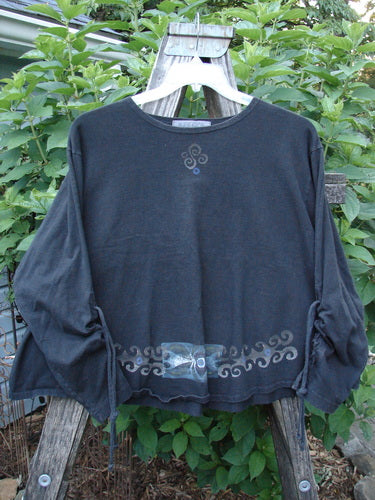 1997 Chandra Top Celtic Holiday Obsidian Size 1 displayed on a hanger, featuring full lower sleeve lacings, rounded wide hemline, rolled neckline, and drawcord back, in perfect condition.