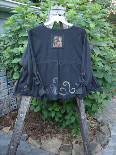 1997 Chandra Top Celtic Holiday Obsidian Size 1 displayed on a wooden rack, featuring full lower sleeve lacings, rounded wide hemline, rolled neckline, and drawcord back.