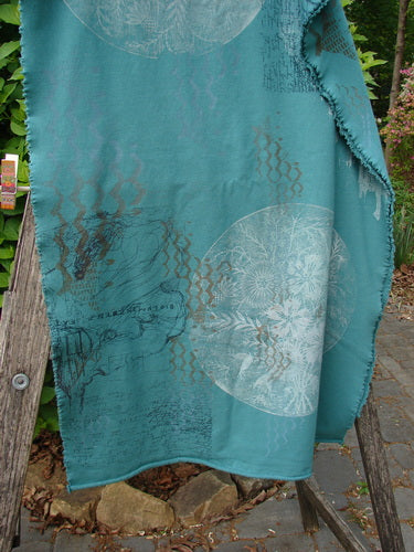 Barclay Heavy Weight Organic Sweatshirt Art Wrap Moon Garden Emerald OSFA draped on a rustic ladder, showcasing intricate mandala motifs and script-style patterns with decorative edgings, highlighting its artisanal design.