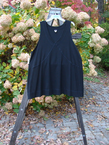 A black Rayon Lycra Rib Crossroad Pullover on a wooden stand, featuring a forgiving A-line shape, V neckline with crisscross stitchery, and a double-paneled hem. Size 2.
