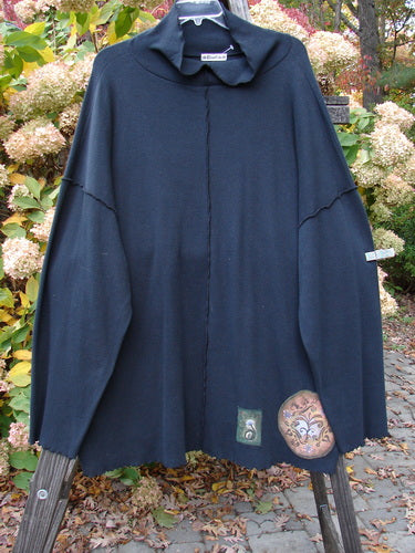 A unique tunic with nature-themed patches, a floppy turtleneck, and cozy long sleeves.