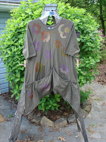 Barclay Quad Pocket Tie Back Tunic Dress Simple Floral Mushroom Size 0 displayed outdoors on a wooden A-frame, featuring an asymmetrical hem, abstract floral patterns, and quad front pockets in a loose-fitting style.