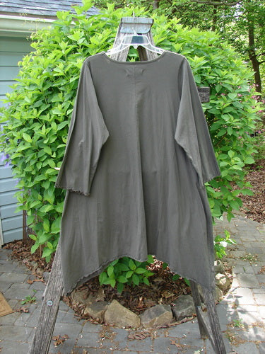 Barclay Three Quarter Sleeve Color Wheel Tunic Falling Floral Black Sand Size 0, draped on a step ladder outdoors, features asymmetrical hem, rounded neckline, and lettuce-edged sleeves, emphasizing artistic, vintage-inspired style.