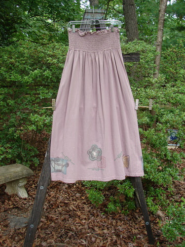 1995 Smocked Skirt Garden Patio Rose Size 2 displayed on a clothesline, showcasing its flowy, full hip design and intricately stitched smocking, perfect vintage piece from the Spring Collection of 1995.