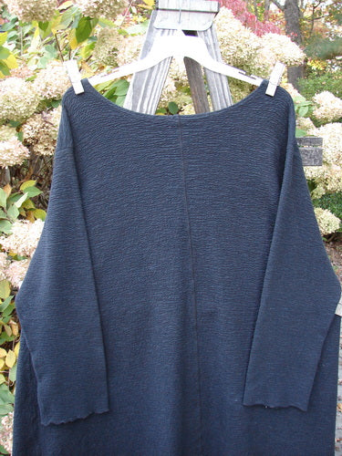 Barclay Crepe Hi Low Top, a black cotton sweater on a clothes line with a textured stretch fabric, rounded neckline, and long cozy sleeves. Size 2.