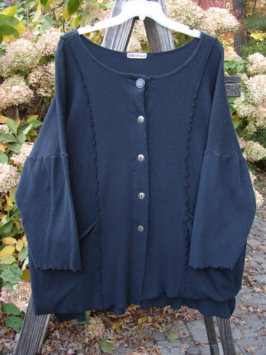 Barclay Thermal Curl Pocket Cardigan Unpainted Black Size 3 displayed on a clothes rack. Vintage Blue Fish Clothing by Jennifer Barclay, featuring dolman sleeves and drop front pockets.