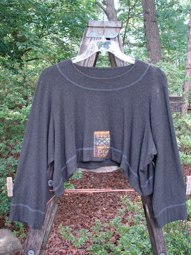 2000 Patched Rayon Lycra Rib Overtop Charcoal Heather Size 1 displayed on a hanger, showcasing its dramatic hemline, exterior stitching, and Celtic-themed painted patches.