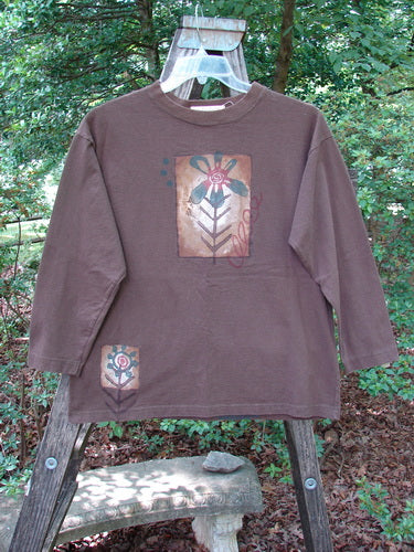 1996 Long Sleeved Tee Single Flower Molasses Size 0, featuring a hand-painted flower design, thicker ribbed neckline, drop shoulders, and a longer square shape, made from mid-weight organic cotton.