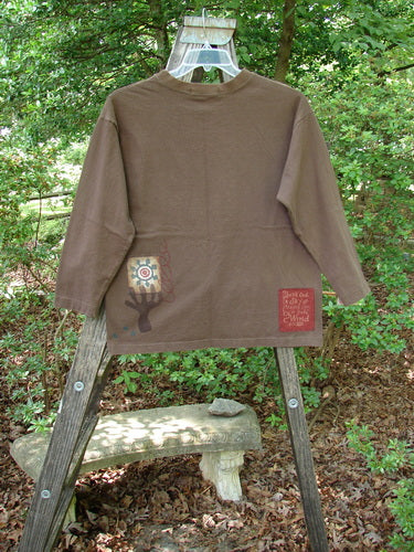 1996 Long Sleeved Tee Single Flower Molasses Size 0 displayed on a wooden ladder, showcasing its drop shoulders, thicker ribbed neckline, and longer square shape, perfect condition from BlueFishFinder’s Fall Collection.