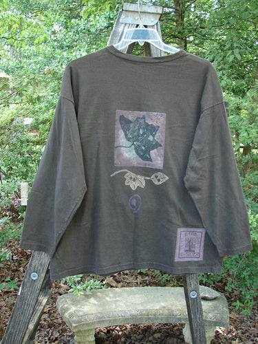 1994 Long Sleeved Tee Forest Leaf Humus Size 1 displayed on a hanger, showcasing a ribbed neckline, drop shoulders, slight A-line shape, and forest leaf theme.