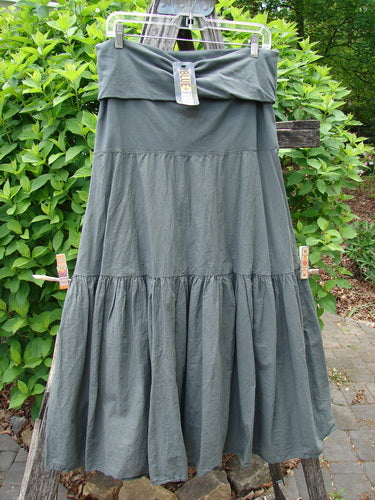 Barclay NWT Batiste Fold Over Silhouette Skirt, hanging with tags on a line, showcases its tiered, A-line design and generous sweep in muted grey-green cotton batiste.