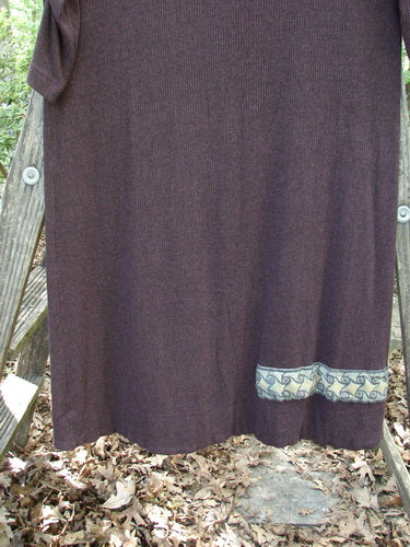 Alt text: 2000 Patched Rayon Lycra Rib Julia Dress Cassis Heather Size 0 displayed on a wooden ladder, showcasing its crisscross sectional front, gathered forearms, and soft rounded neckline.