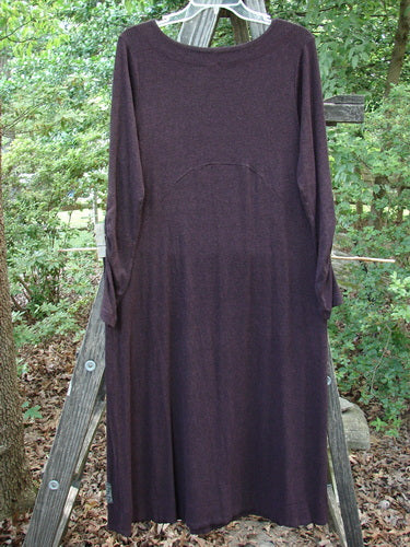 Alt text: 2000 Patched Rayon Lycra Rib Julia Dress Cassis Heather Size 0 on a wooden rack, showcasing its long, flowing design with a crisscross front and gathered forearms.