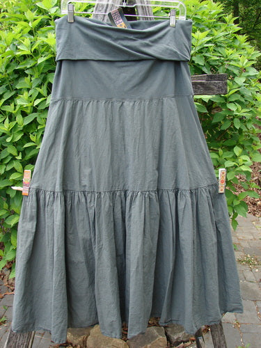 Barclay NWT Batiste Fold Over Silhouette Skirt, Unpainted Chimera Size 1, displayed on a hanger outdoors, showcases lightweight cotton batiste fabric with a tiered maxi design and soft waistline.