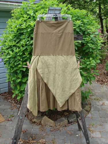 Barclay Fold Over Silk Accent Silhouette Skirt Unpainted Bone Size 0, featuring a layered maxi design with asymmetrical ruffles, hangs outdoors, showcasing its elegant flouncy A-line flair and forgiving waistline.
