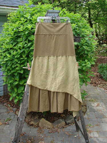 Barclay Fold Over Silk Accent Silhouette Skirt Unpainted Bone Size 0, tiered with asymmetrical hem, hangs on a weathered step-ladder, showcasing its elegant A-line flair and lightweight cotton batiste fabric.