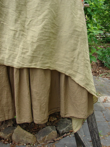 Barclay Fold Over Silk Accent Silhouette Skirt Unpainted Bone Size 0, featuring a layered design with a light olive-beige bias-cut top layer over a darker earth-brown layer, displayed on a wooden stand outdoors.