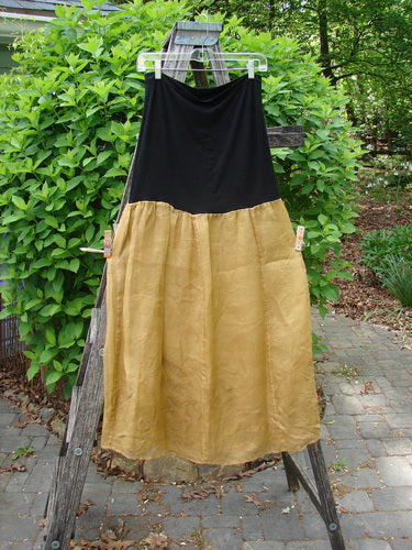 2000 Silk Organza Aios Dana Skirt Celtic Wind Bone Size 0, featuring a black lycra upper panel and mustard-gold lower flare, elegantly displayed on a wooden ladder outdoors, epitomizing vintage Bluefishfinder style.