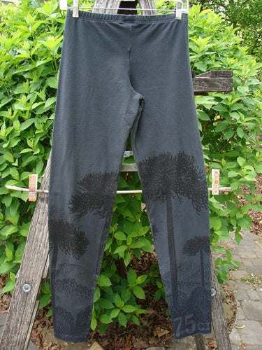 Barclay Cotton Lycra Relaxed Legging Shadow Tree Lux Silhouette Size 0 displayed outdoors, draped on a wooden ladder, featuring subtle tree-silhouette prints on the lower legs, embodying relaxed elegance from Bluefishfinder.com.