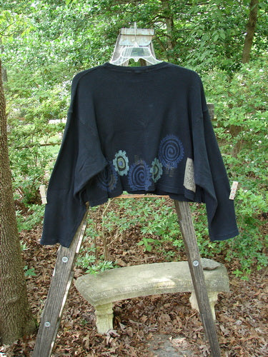 1996 Thermal Boxy Top Gear Black OSFA, displayed draped over a wooden ladder in an outdoor forest setting, showcasing its wider, boxier shape with ribbed neckline and longer arm lengths.