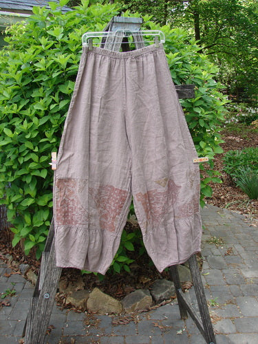 Barclay Linen Meadow Pant Celtic Vine Stone Oriel Size 0 features wide, flowy legs and a patterned band, draped on a ladder outdoors, embodying Bluefishfinder.com’s vintage, creative, and expressive style.