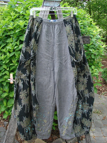 Barclay Linen Pucker Accent 4 Square Pant Tropical Black Grey Size 0: Wide-leg trousers with gray linen center, black foliage-print side panels and pockets, displayed outdoors, showcasing drape and movement against greenery.