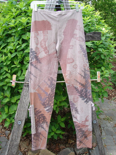 Barclay Cotton Lycra Side Gather Legging Forest Moon Oriel Size 0 displayed on a wooden frame, showcasing slim-fit design, fern-and-leaf pattern, and drawcord-accented tapering lowers in an outdoor setting.