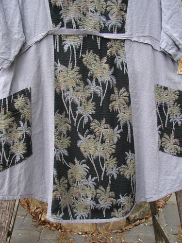 Barclay Linen Pucker Heart and Soul Dress in Tropical Black Grey, featuring a deep V-neck, contrasting palm-tree-patterned pockets, and a textured A-line shape with raw-edged empire waist seam.