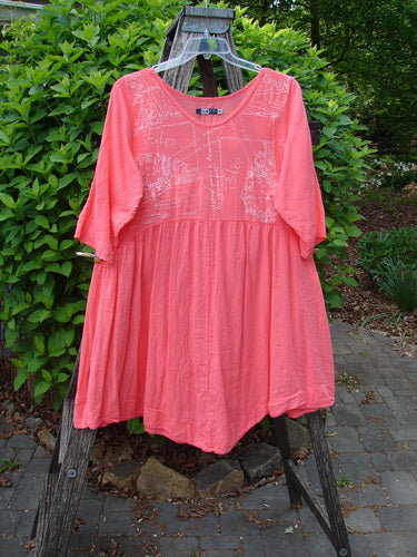 Barclay Linen Two Pocket Dolly Dress Notes Coral Size 0 displayed on a wooden stepladder, featuring a scoop neckline, elbow-length sleeves, and faint floral embroidery, embodying vintage elegance from Bluefishfinder.com.